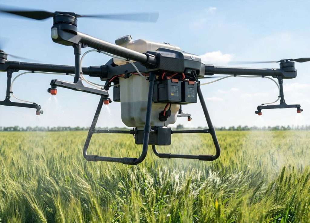 Agricultural spraying drone flying over a green crop field